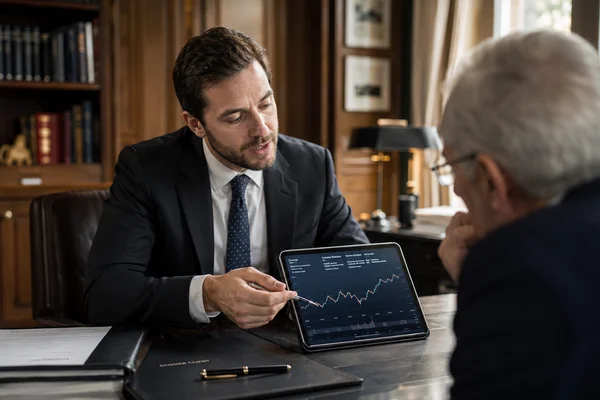 Conseiller en investissement financier en consultation client devant un graphique boursier en Moselle