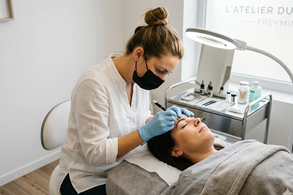 Praticienne en microblading réalisant une prestation sourcils en Moselle